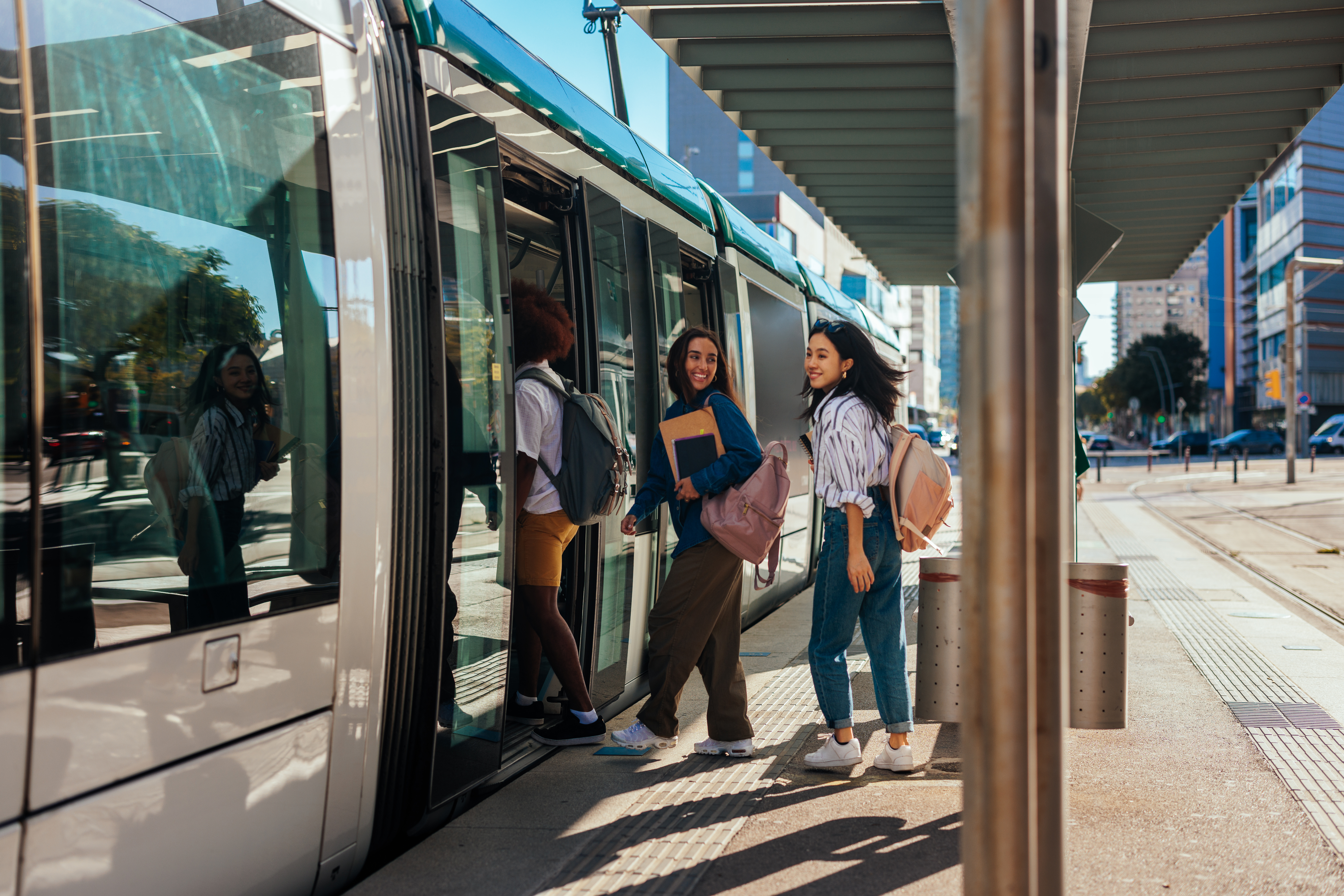 Three girls entering a tram