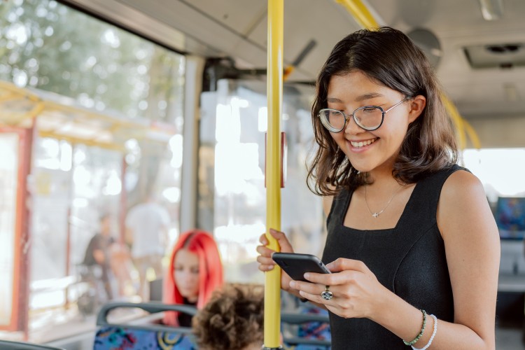 A girl looking into her phone in a bus. 