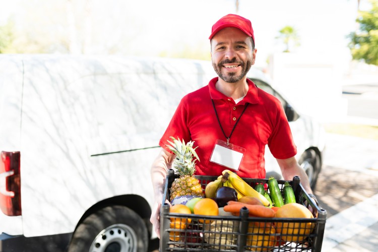 A delivery man delivering fresh fruit.
