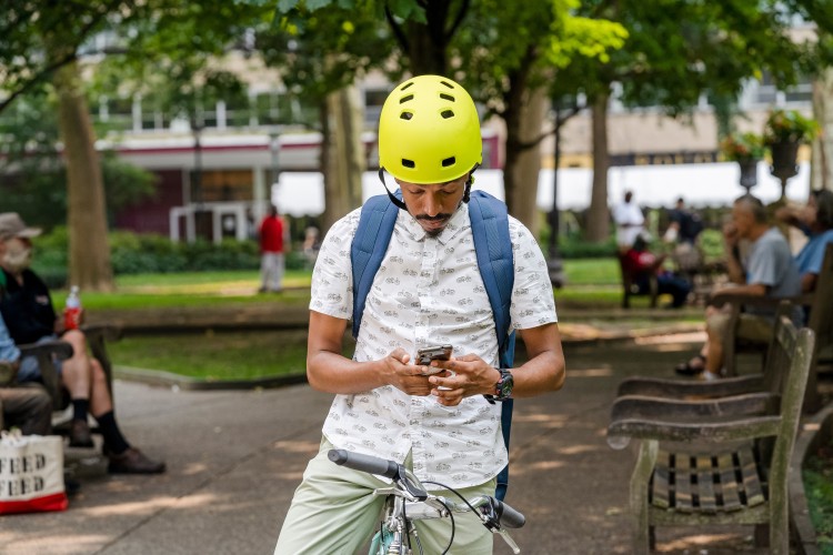 A man on a bike looking into his phone.