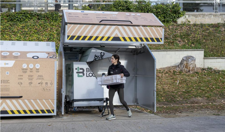 A person using a bike locker to collect her parcel. 