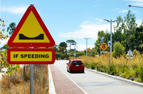 Car driving on a low speed area, where there is a bump installed.