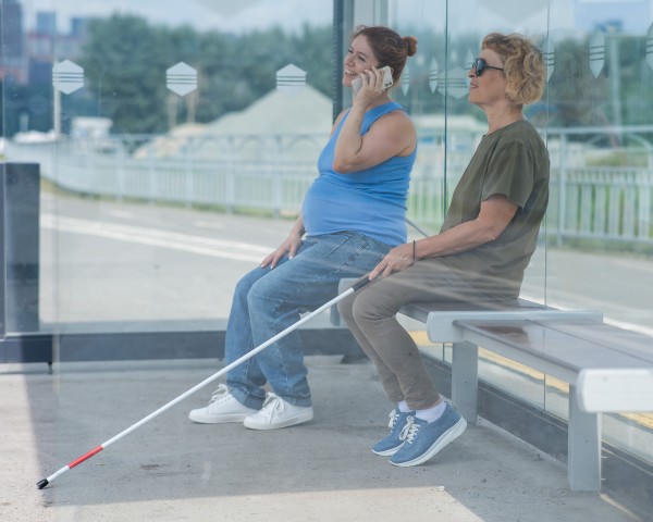 An elderly blind woman and a pregnant woman are sitting at a bus stop and waiting for the bus. Descargado    Archivo n.°:  767495555 An elderly blind woman and a pregnant woman are sitting at a bus stop and waiting for the bus