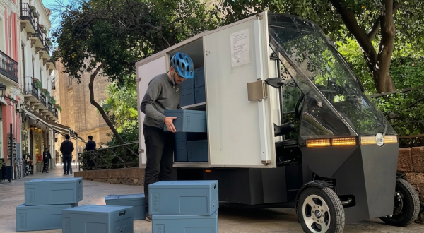 A cargo-bike driver putting refrigerated boxes in the cargo box