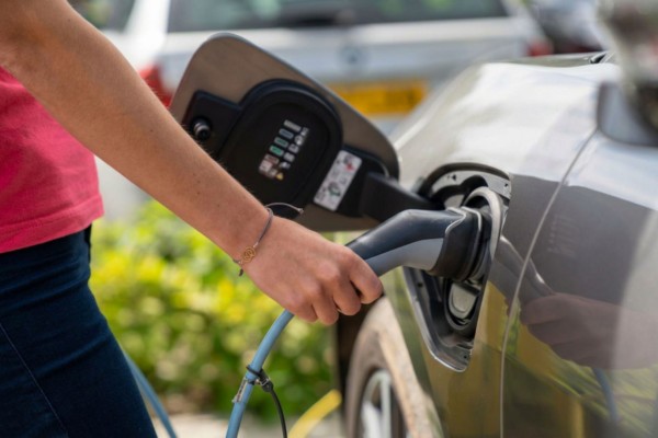 Person charging an electric vehicle.