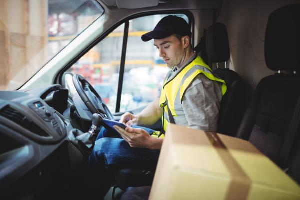 Delivery driver using a device in the van. 