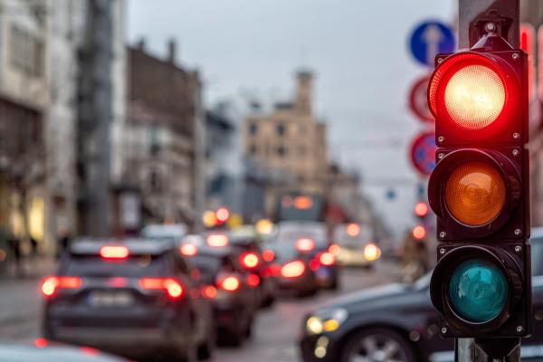 Traffic lights in a busy street with cars.