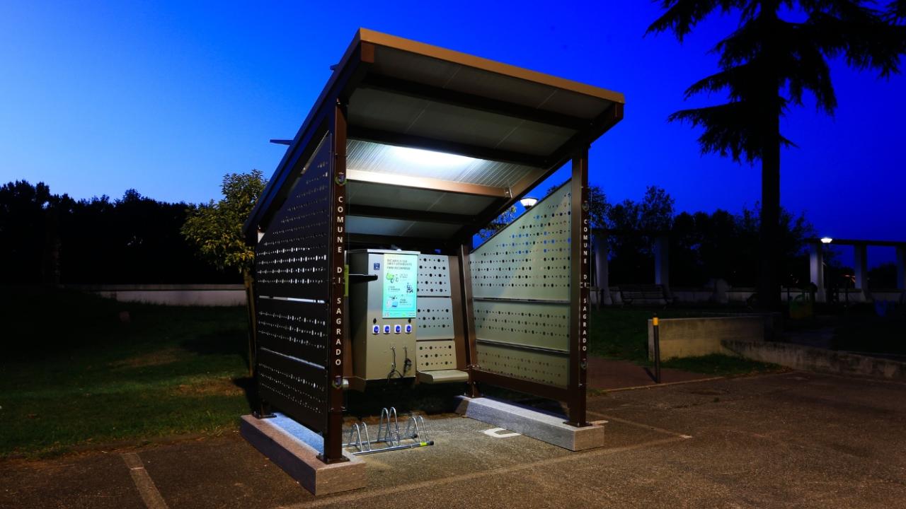 The Margherita Shelter illuminated at night, providing a well-lit charging station in a park.