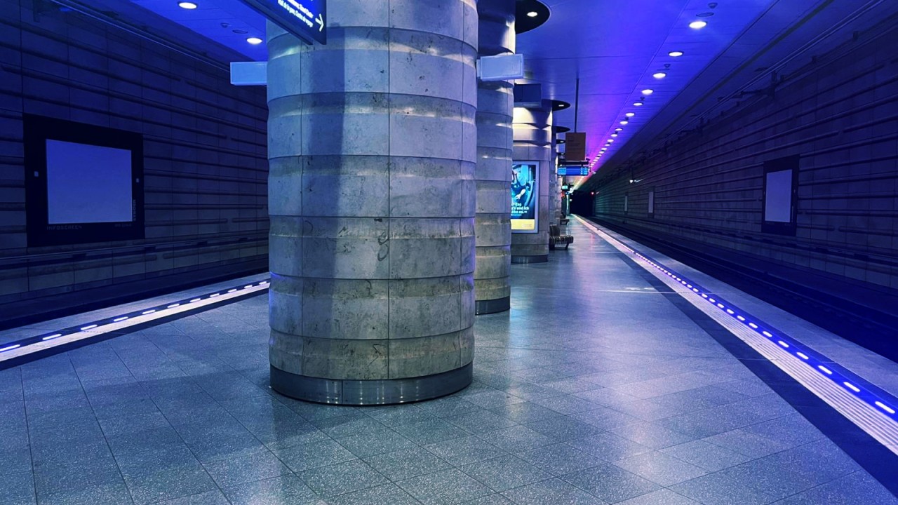 Underground train platform with blue ambient lighting and integrated illuminated platform edge for smart station design.