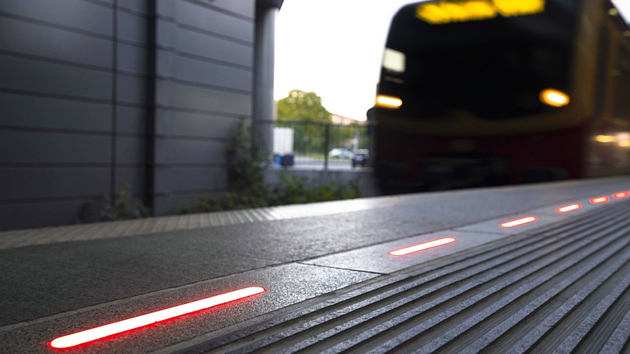 Close-up of a red illuminated platform edge at a train station, signaling danger and improving passenger awareness and safety.