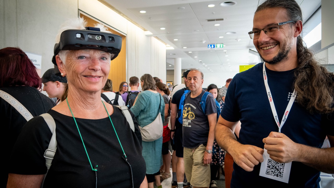 a visually impaired person experiencing the Glasses at SightCity, for the first time. Next to the lady testing is our Robert, Head of Navigation