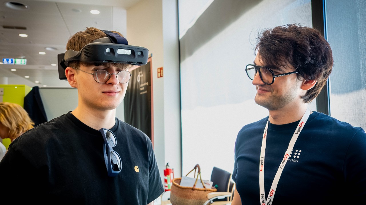 A blind teenager experiencing the Glasses at SightCity, for the first time. Next to the lady testing is Cornel Amariei, founder & CEO of .lumen
