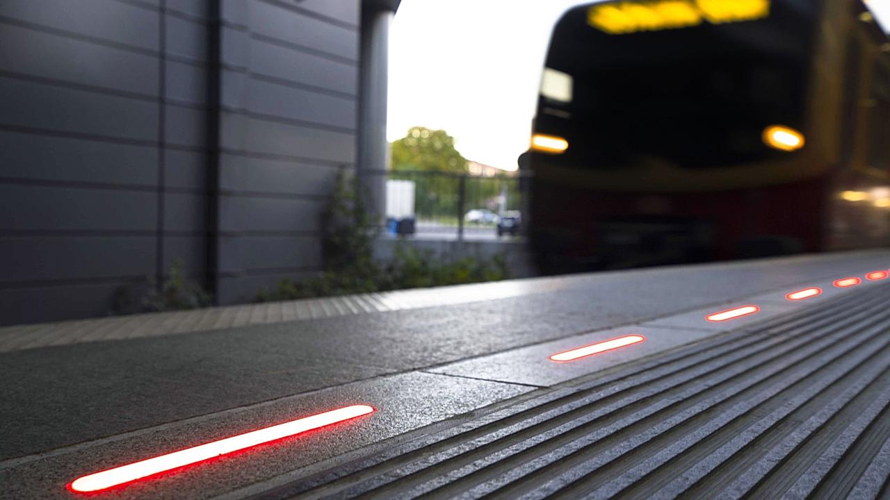 Close-up of a red illuminated platform edge at a train station, signaling danger and improving passenger awareness and safety.